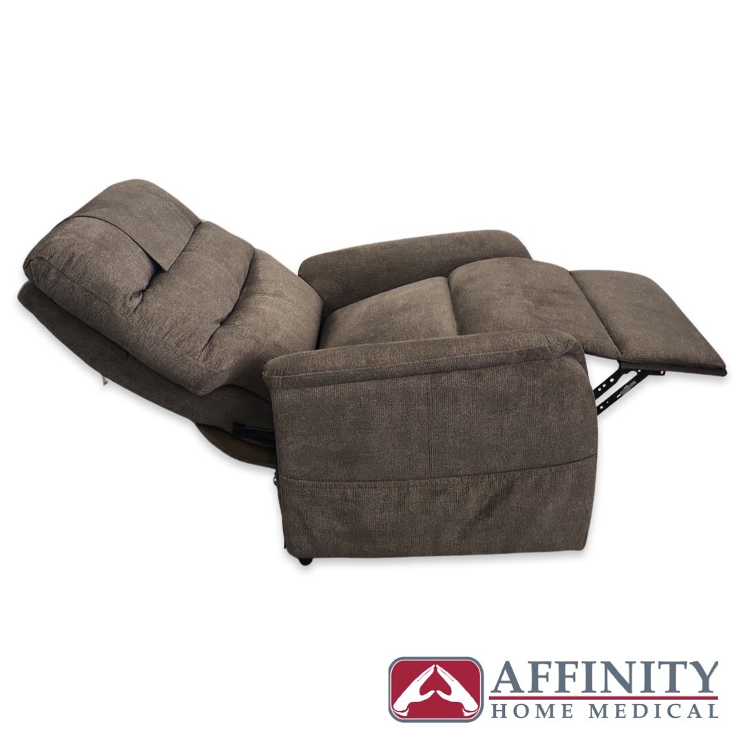 Power lift recliner chair in brown fabric shown fully reclined with footrest extended, viewed from the side angle