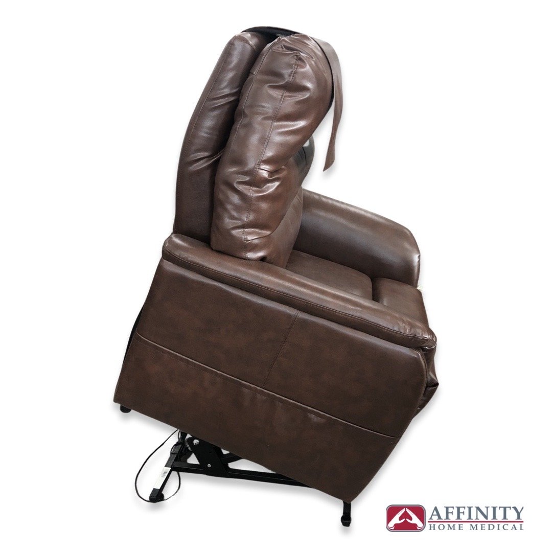 Power lift recliner chair in chestnut brown vinyl shown from the side in fully reclined position with lift mechanism visible