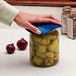 Dycem non-slip jar opener pad being used to open a glass jar of pickles on a kitchen counter