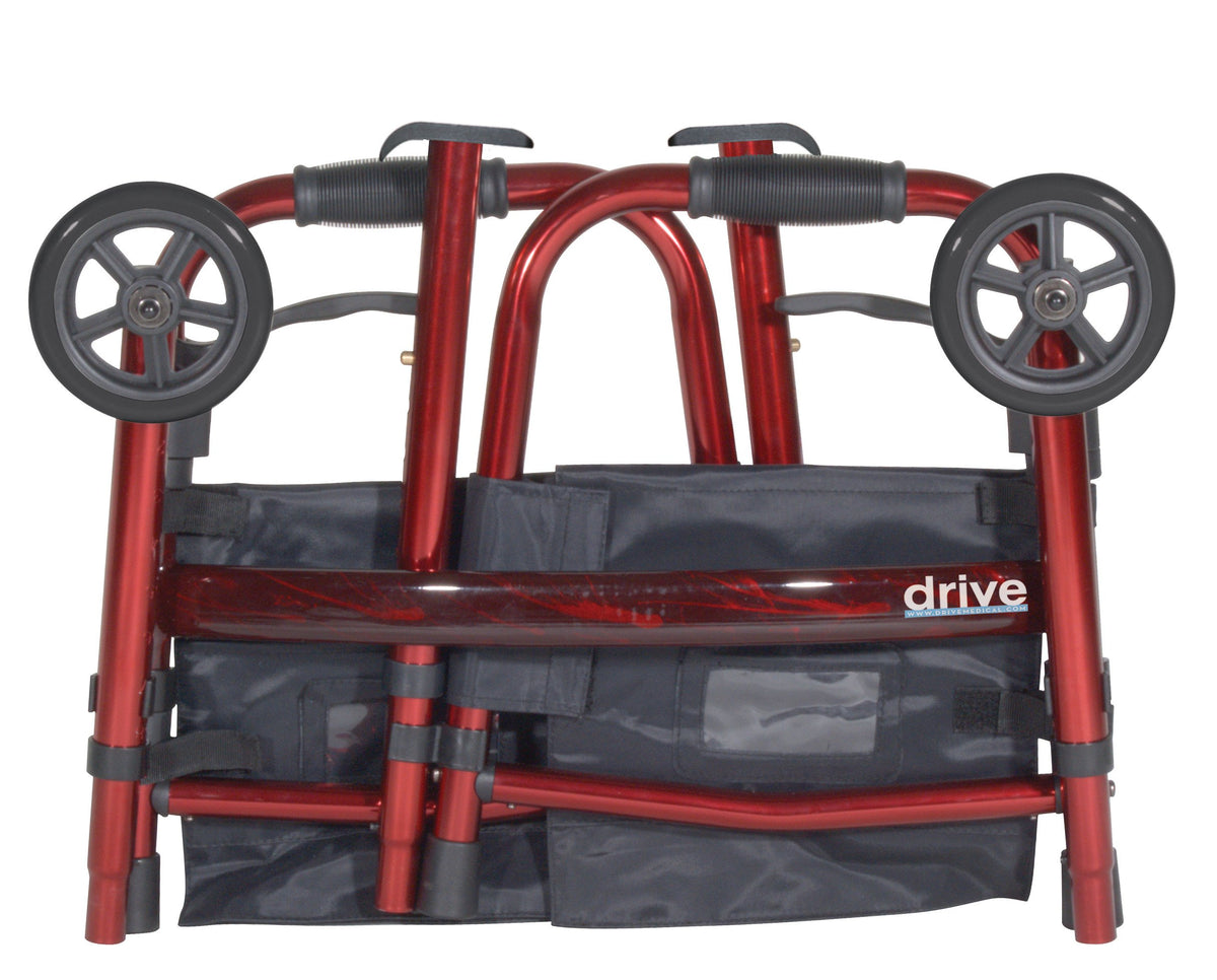 Rollator walker folded flat, showing red frame, gray wheels, hand brakes, and navy storage bag with Drive branding