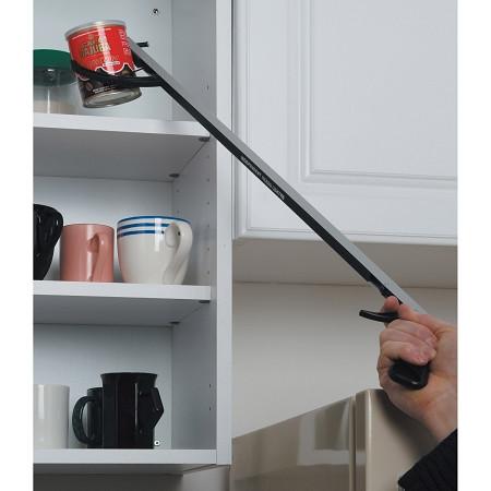 Reacher grabber tool being used to retrieve a can from a high kitchen cabinet shelf, shown in use by a hand