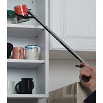 Reacher tool extending toward kitchen cabinet shelves, held by a person's hand
