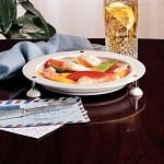 Triangular suction plate holding a colorful meal on a wooden table with a drink in the background