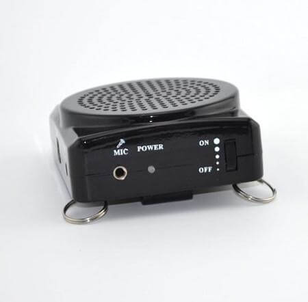 Portable pocket PA voice amplifier in black with speaker grille, power switch, mic jack, and metal attachment rings