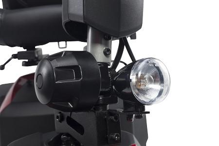 Power scooter front headlight and horn mounted on black metal frame, close-up detail view